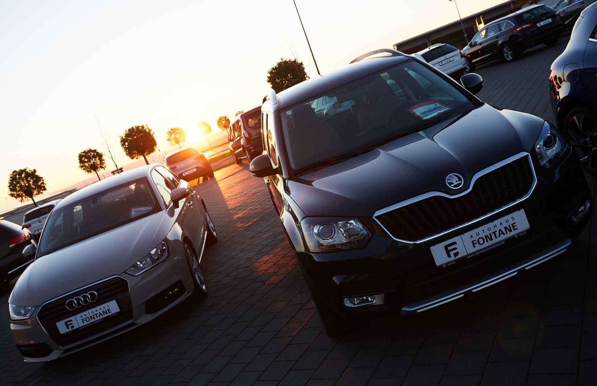Fahrzeuge auf dem Hof im Gegenlicht der tiefstehenden Sonne